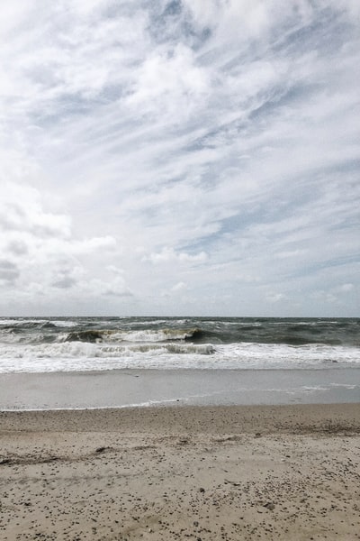 白天，海浪在白云下拍岸